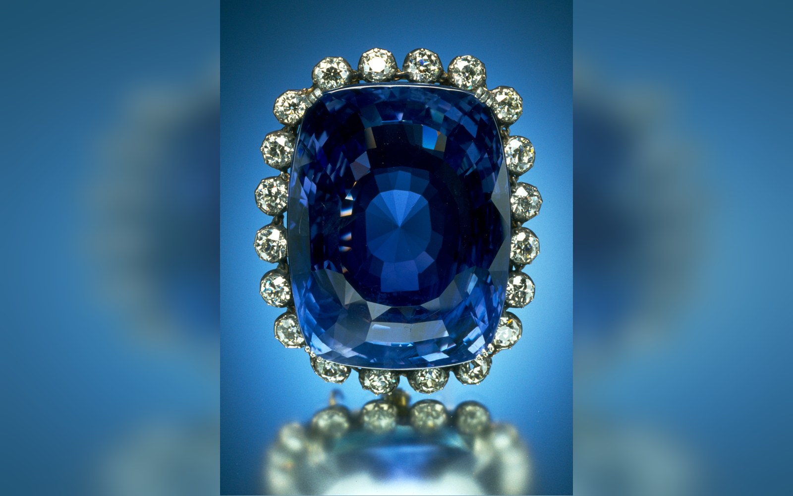 Large cushion-cut blue sapphire surrounded by a ring of diamonds