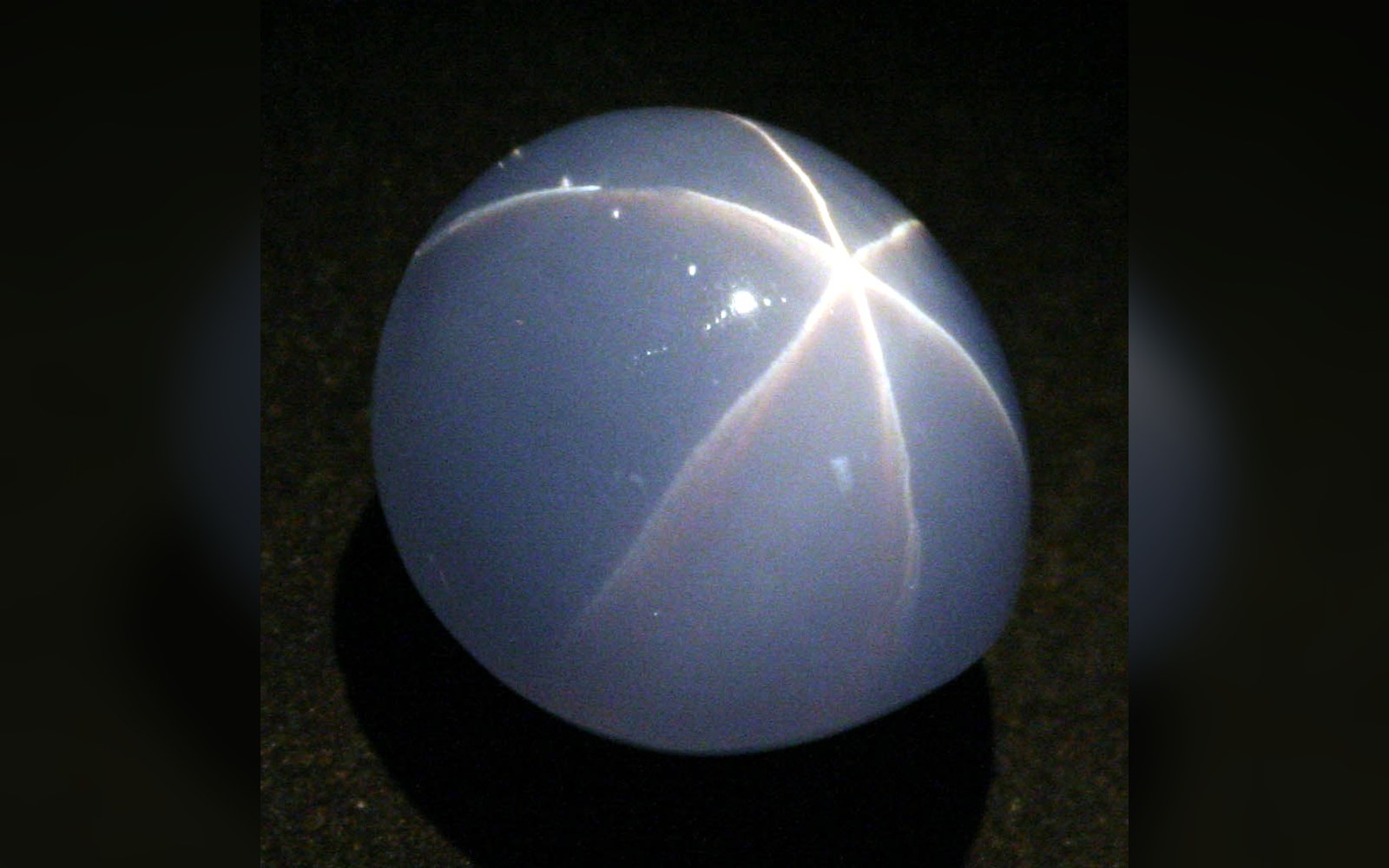 Cabochon-cut star sapphire showing a six-rayed light pattern across its domed surface